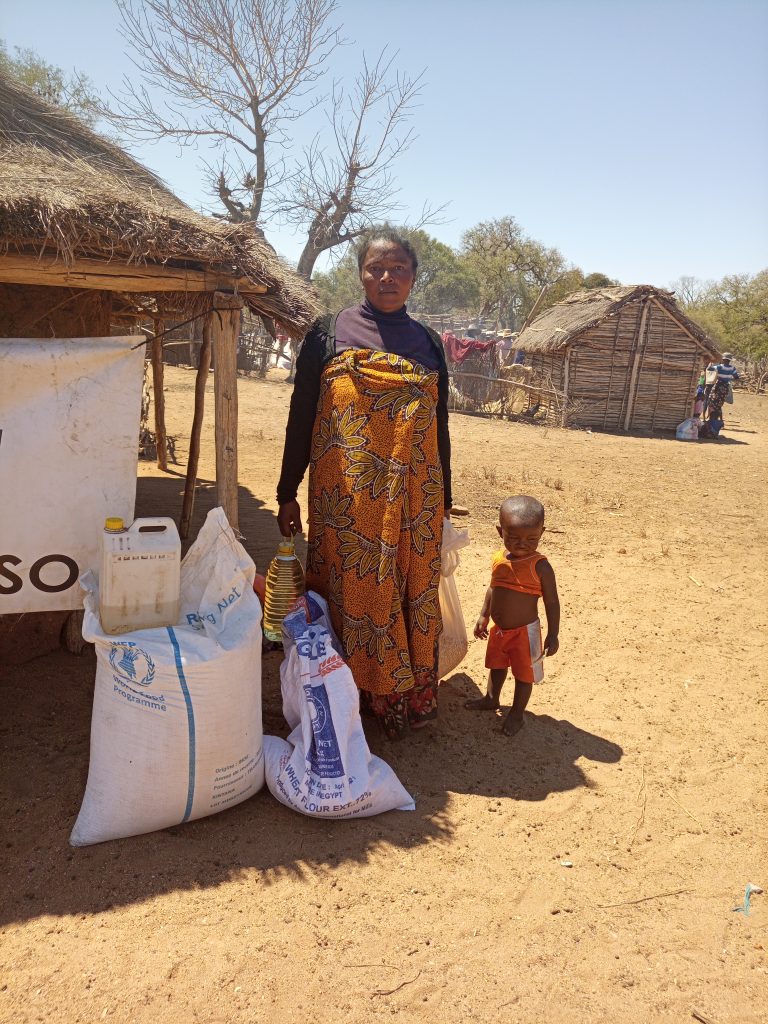 Cette femme de ménage vient de récevoir une aide alimentaire faite par le PAM. Les enfants aussi bénéficient d'une aide (Prévention de la Malnutrition)